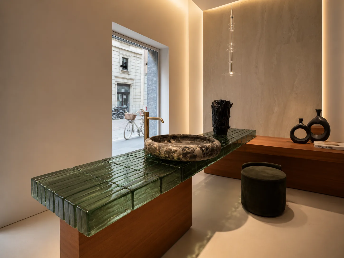 Moderner Waschtisch mit transluzenter grüner Glasstruktur, Natursteinbecken und minimalistischer Lichtplanung auf dem Salone del Mobile 2026 in Mailand