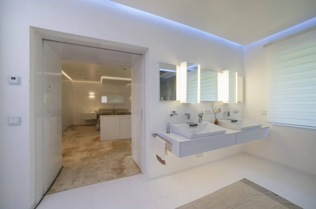 Bad en Suite mit offenem Übergang zwischen Schlafzimmer und Badezimmer, geplant von Torsten Müller mit integrierter Lichtführung und durchgängiger Raumgestaltung