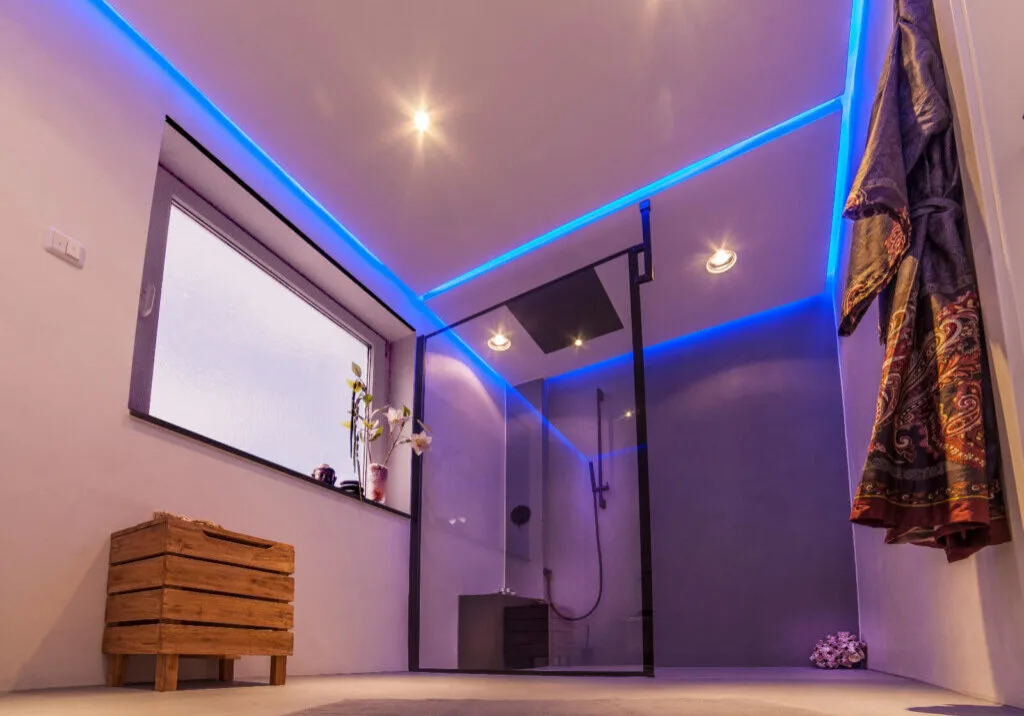 Fugenloses Bad in hellem Taupeton mit blauer LED-Beleuchtung
