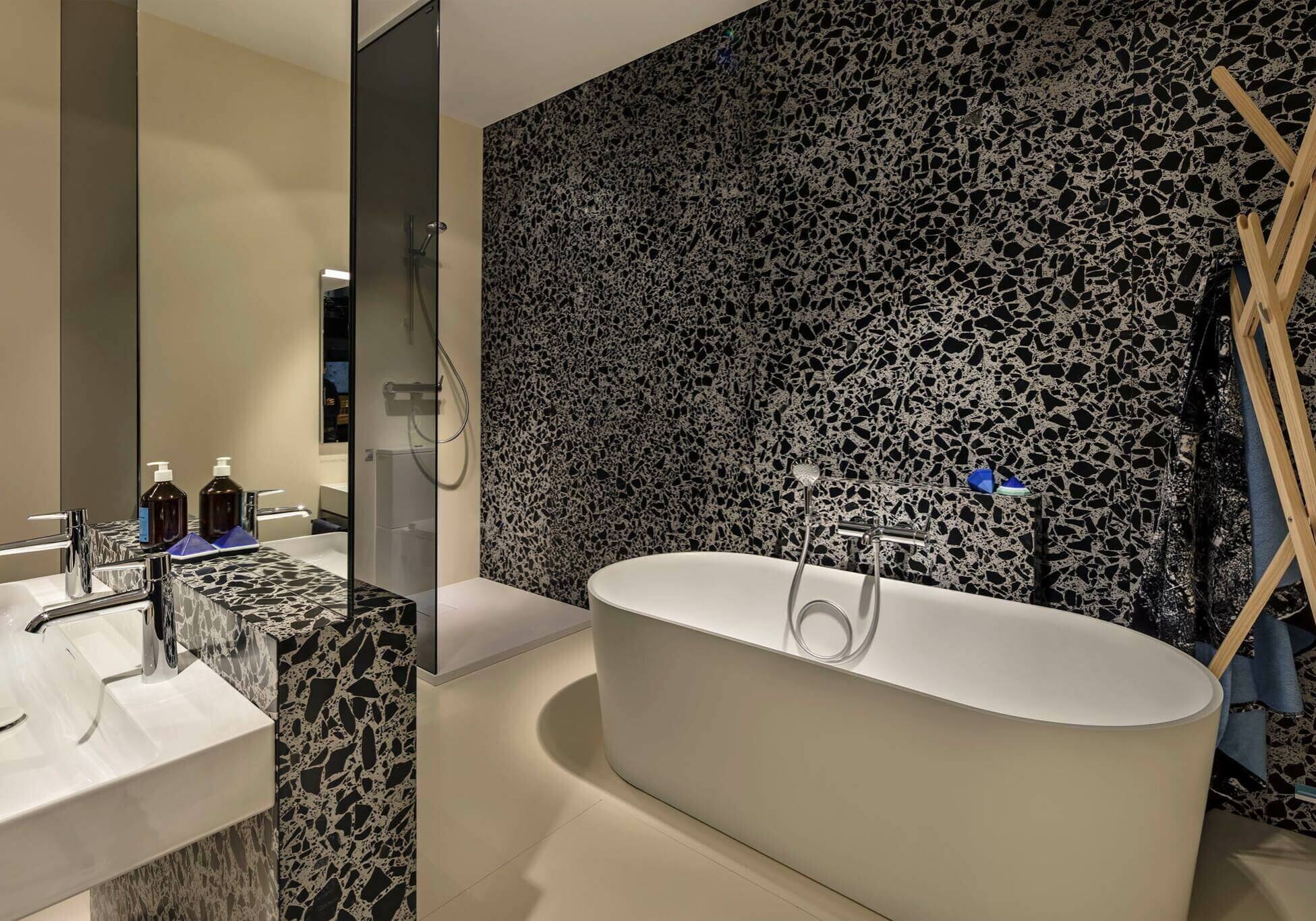 Weiße Badewanne von Laufen Bathrooms vor schwarzer Granitwand