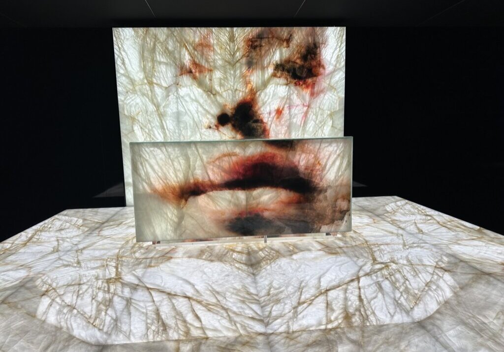 Beleuchtete Naturstein-Installation „The Language of Stone – Vision of Art“ von Antolini × Murran Billi auf der Marmomac 2025, kunstvoll inszenierter Quarzit mit roten Akzenten.