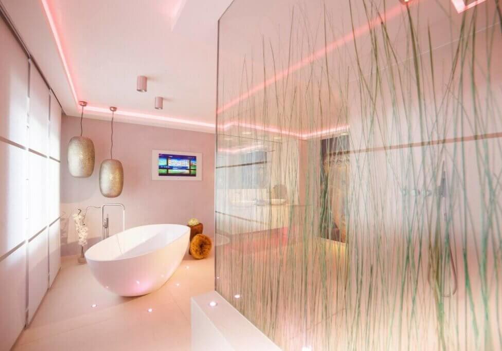 Badezimmer mit pink beleuchteter Dusche und Gräsern - Badezimmer Trends 2024